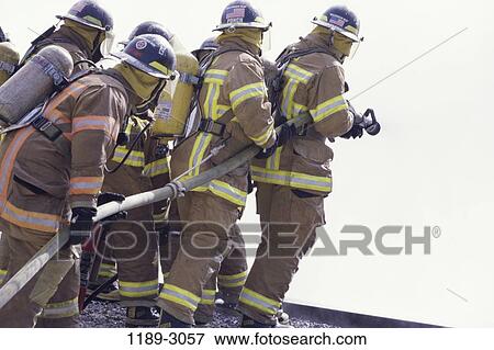 Stock Photo - industry, pulling, teamwork, uniforms, hose, firemen, pull. Fotosearch
