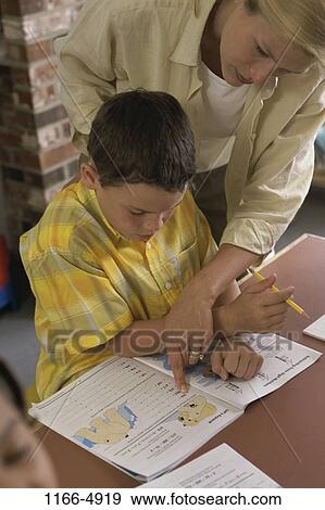 Stock Photo - instructing, people, teacher, school, book, boy, explaining. Fotosearch