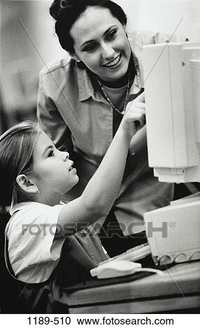 Stock Image - instructing, people, woman, teacher, computer, classroom, girl. Fotosearch