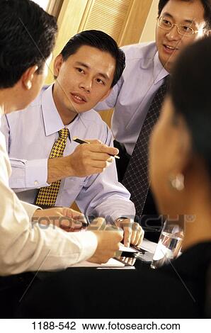 Stock Image - meeting, Asian, business, indoors, businesspeople, Businesspeople conferring. Fotosearch