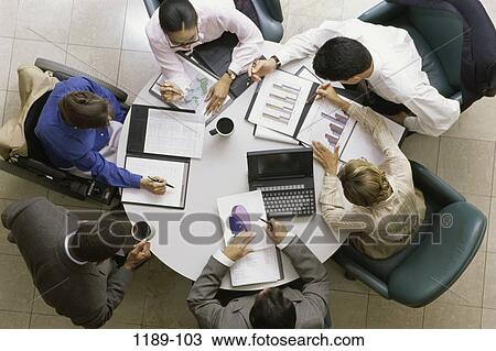 Stock Image - meeting, group, multiethnic, overhead, table, charts. Fotosearch