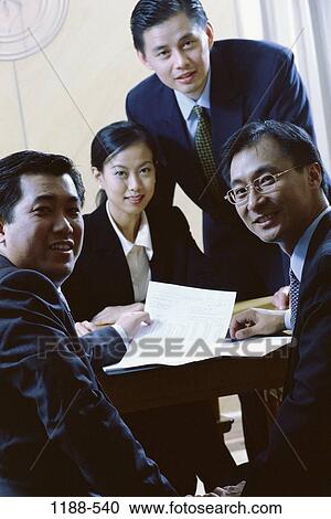 Stock Image - meeting, people, Asian, business, indoors, document. Fotosearch