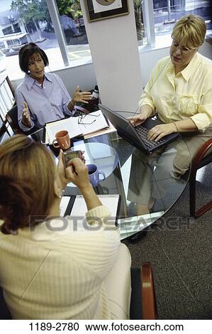 Stock Image - meeting, women, coworkers, talking, discussion, conversation, business. Fotosearch