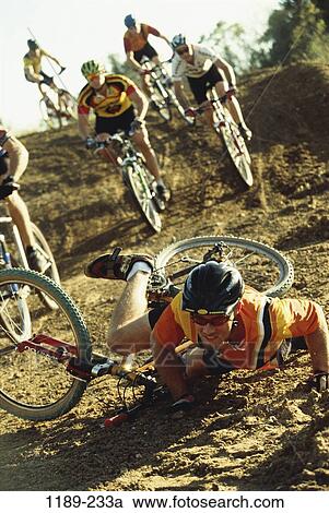 Stock Image - men, people, racing, bicycle, dirt, injury, sports. Fotosearch
