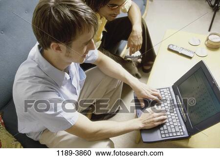 Stock Image - multiethnic, men, people, home, keyboard, monitor, table. Fotosearch