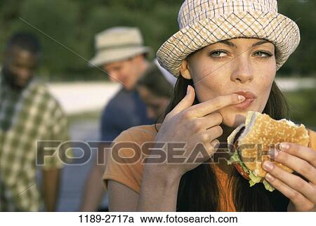 Stock Image - multiethnic, people, eating, hat, outdoors, friends. Fotosearch