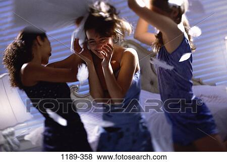 Stock Photo - multiethnic, people, party, feathers, floating, night, bed. Fotosearch