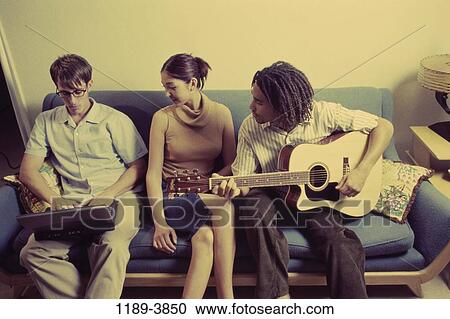 Stock Image - multiethnic, people, sitting, laptop, guitar, friends. Fotosearch