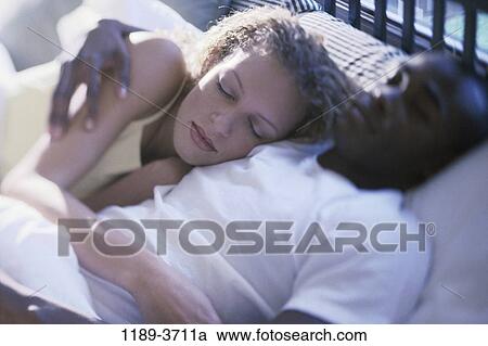 Stock Image - multiethnic, people, sleeping, couple, indoors, Caucasian, sleep. Fotosearch