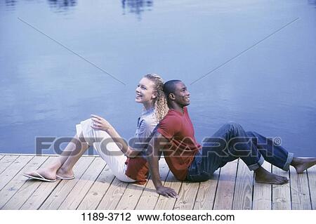multiethnic, people, water, couple, sitting, lake, leaning View Large Photo Image Stock Image - multiethnic, people, water, couple, sitting, lake, leaning. Fotosearch
