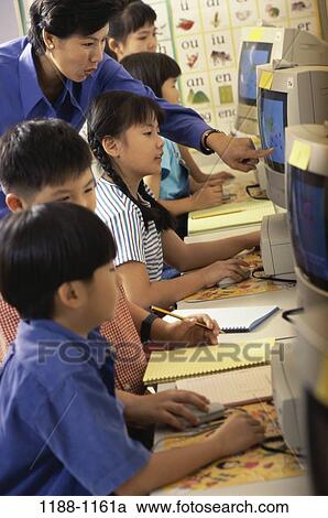 people, Asian, teacher, school, computer, classroom, pointing View Large Photo Image Stock Image - people, Asian, teacher, school, computer, classroom, pointing. Fotosearch