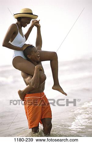 people, balance, hat, couple, beach, laughing, joyous View Large Photo Image Stock Photo - people, balance, hat, couple, beach, laughing, joyous. Fotosearch