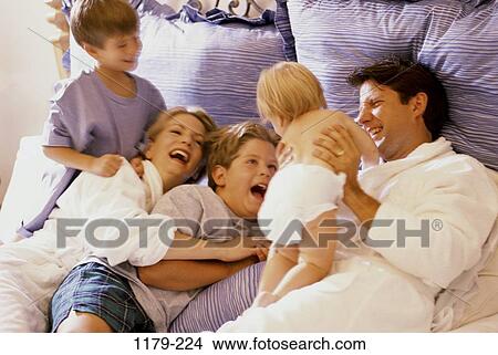 Picture - people, bed, laughing, nurturing, joyous, commitment, family. Fotosearch
