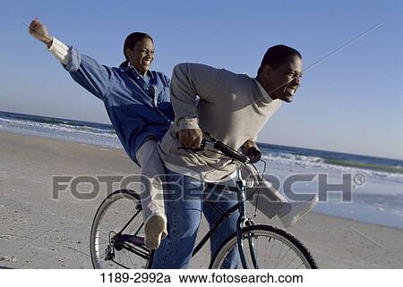 Stock Image - people, couple, bicycle, beach, riding, bike, tandem. Fotosearch