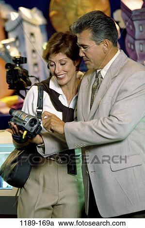 Stock Image - people, couple, Middle-aged, shopping, camera, picking, video camera. Fotosearch