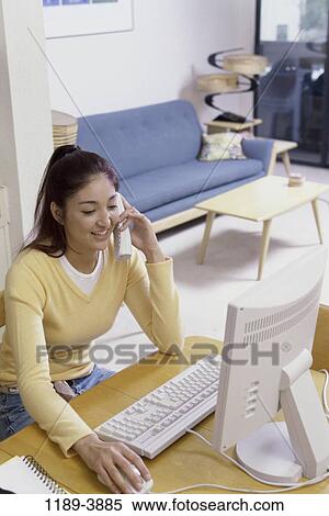 Stock Photography - people, desk, home, telephone, talking, mouse, technology. Fotosearch