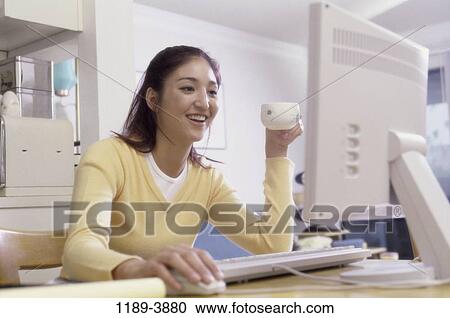 Stock Image - people, desk, home, woman, smiling, Asian. Fotosearch