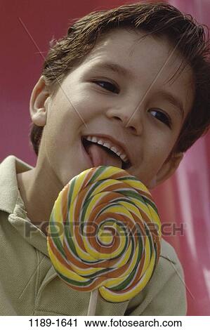Stock Image - people, eating, licking, Hispanic, candy, boy, child. Fotosearch