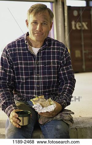 Stock Photo - people, eating, smiling, sitting, worker, outdoors. Fotosearch