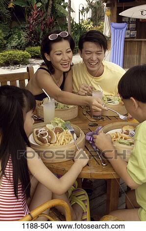 Picture - people, eating, smiling, table, Asian, sitting, laughing. Fotosearch