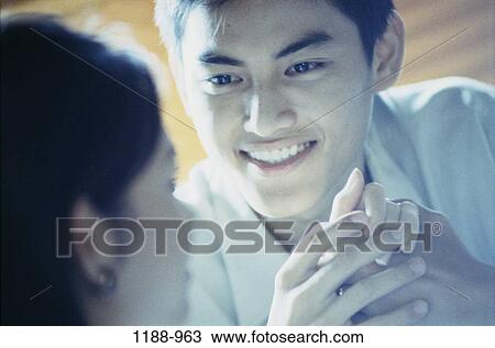 Stock Image - people, hands, smiling, talking, Asian, couple, holding. Fotosearch