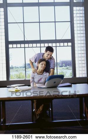 Stock Image - people, home, smiling, table, couple, window, technology. Fotosearch
