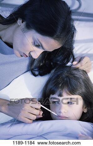 Picture - people, mother, Hispanic, bed, thermometer, family, daughter. Fotosearch