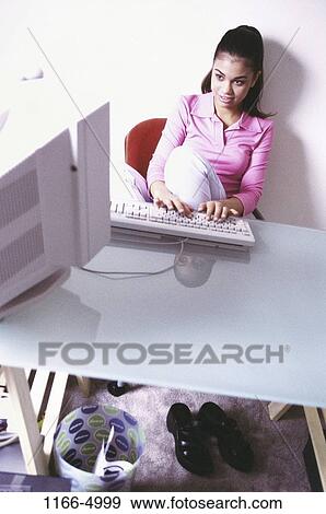 Stock Photo - people, reflection, desk, home, technology, sitting, Hispanic. Fotosearch