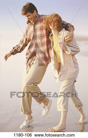 Stock Photograph - people, relaxation, walking, couple, beach, laughing, Middle-aged. Fotosearch