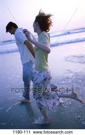 Stock Image - people, running, couple, beach, laughing, adventurous, Middle-aged. Fotosearch