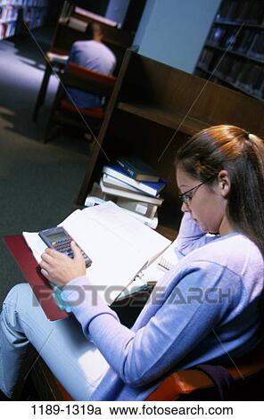 Stock Image - people, school, reading, homework, studying, library, education. Fotosearch