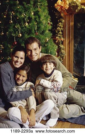 Stock Image - people, smiling, Christmas, hugging, smile, family, Christmas tree. Fotosearch