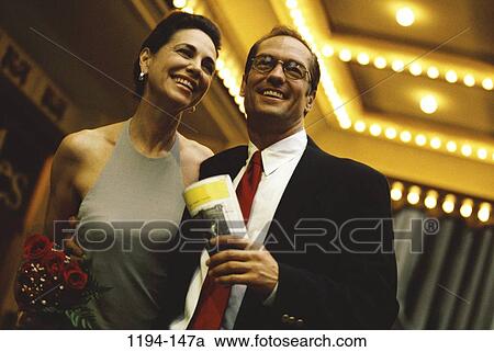 people, smiling, suit, couple, theater, holding, flowers View Large Photo Image Stock Image - people, smiling, suit, couple, theater, holding, flowers. Fotosearch