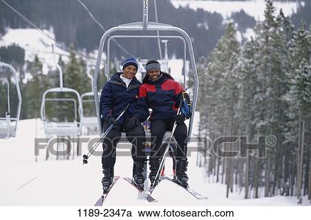 Stock Image - people, snow, smiling, couple, skiing, winter, ski lift. Fotosearch