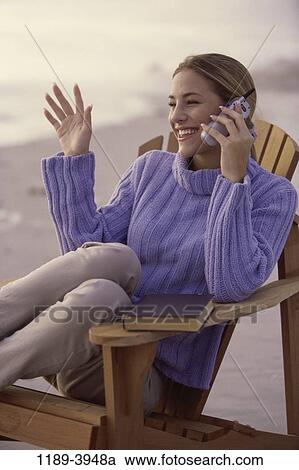 Stock Image - people, woman, telephone, talking, chair, phone, beach. Fotosearch