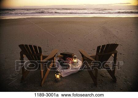 Stock Image - picnic, evening, sunset, beach, chairs, vacation, food. Fotosearch
