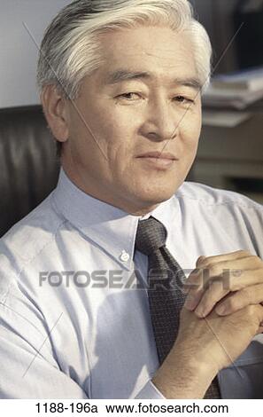 Stock Image - serious, senior, looking, Middle-aged, business, Asian. Fotosearch