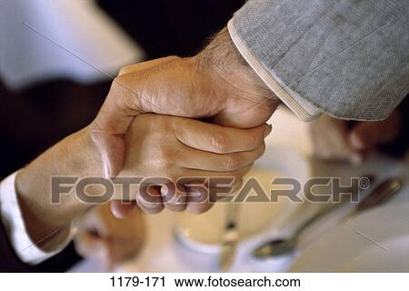 Stock Image - teamwork, commitment, agreement, alliance, handshake, indoors, trust. Fotosearch