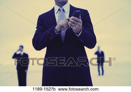 Stock Image - telephone, phone, business, outdoors, cell phone, cell, Businesspeople outdoors phone. Fotosearch