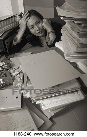 Stock Image - woman, paperwork, Asian, overwhelmed, business, chaotic, administrative. Fotosearch