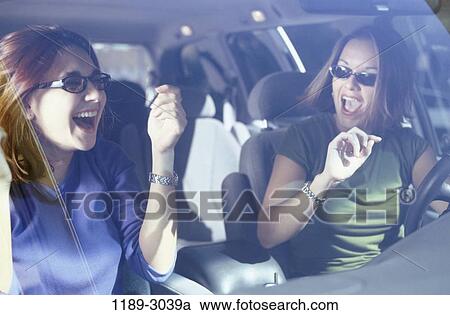 Stock Image - women, people, car, driving, laughing, sunglasses, outdoors. Fotosearch