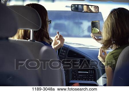 Stock Image - women, people, car, driving, outdoors, makeup, distracted. Fotosearch