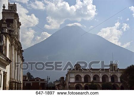 Stock Photo - Buildings in a city with a volcanic mountain in the background, Agua Volcano, Antigua, Guatemala. Fotosearch