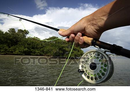 Close-up of a person's hand holding a fishing rod View Large Photo Image Stock Image - Close-up of a person's hand holding a fishing rod. Fotosearch