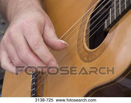 Close-up of a person's hand playing a guitar, Buenos Aires, Argentina View Large Photo Image Stock Photography - Close-up of a person's hand playing a guitar, Buenos Aires, Argentina. Fotosearch