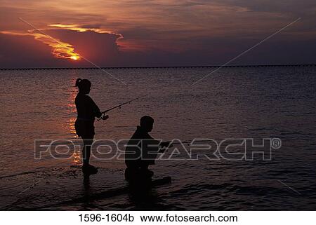 Stock Image - Couple fishing, Lake Pontchartrain, Bayou Sauvage National Wildlife Refuge, Louisiana, USA. Fotosearch