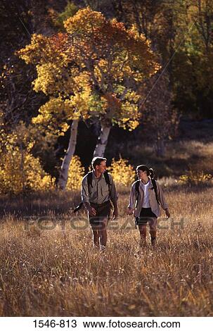 Couple hiking in a field with aspen trees in the background, California, USA View Large Photo Image Stock Image - Couple hiking in a field with aspen trees in the background, California, USA. Fotosearch