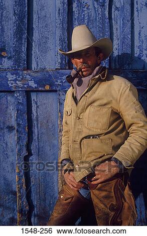 Cowboy leaning against a door and smoking a pipe View Large Photo Image Stock Photograph - Cowboy leaning against a door and smoking a pipe. Fotosearch