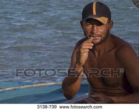 Stock Photo - Fisherman repairing a net, Natal, Rio Grande do Norte, Brazil. Fotosearch