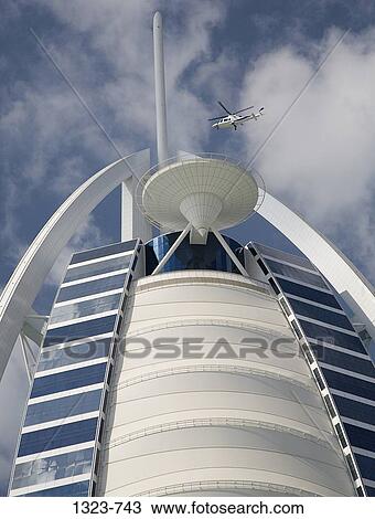 Low angle view of a helicopter flying over a hotel, Burj Al Arab Hotel, Dubai, United Arab Emirates View Large Photo Image Stock Image - Low angle view of a helicopter flying over a hotel, Burj Al Arab Hotel, Dubai, United Arab Emirates. Fotosearch